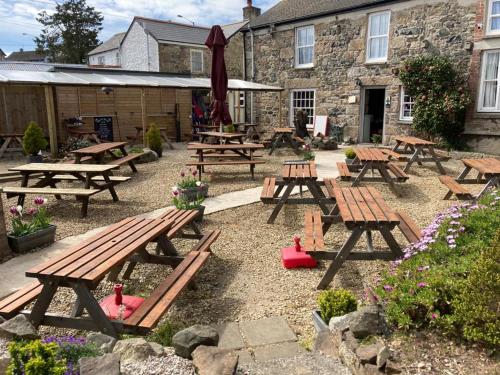 a group of picnic tables in front of a building at The Pirate Inn in Newlyn