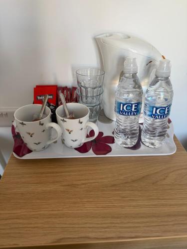 a tray with two cups and two bottles of water at The Gallery in Lancing