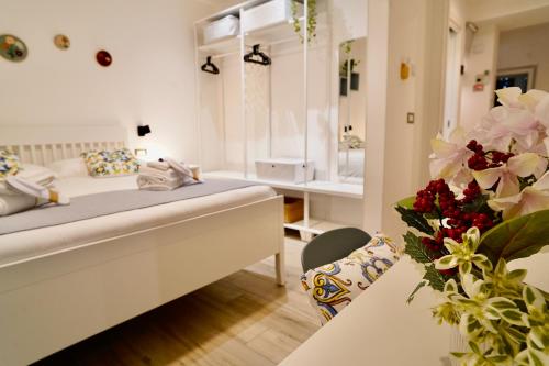Cette chambre comprend un lit et une table fleurie. dans l'établissement Villa RiRò Bari, à Bari