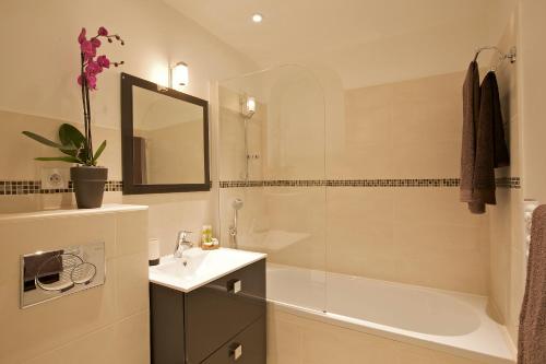 a bathroom with a tub and a sink and a shower at Le California in Juan-les-Pins