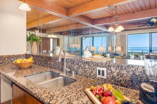 une cuisine avec un évier et un comptoir avec un bol de fruits dans l'établissement Kahana Outrigger 3A2 · KHO 3A2 Updated OceanFront 3BD wPool AC O, à Kahana