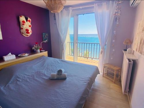 Un dormitorio con una cama con vista al mar. en PARADIS exceptionnel surplombant la MER- accès direct plage/ 8 Pers., en Carry-le-Rouet