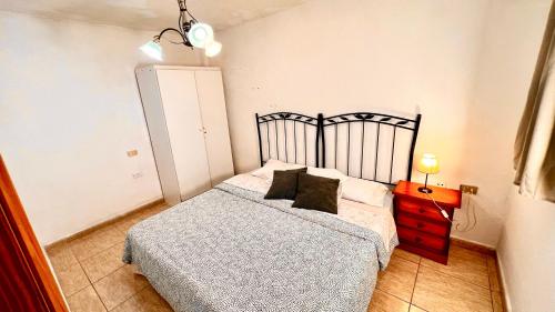 圣胡安海滩Apartment in the center of San Juan beach!的一间卧室配有一张床和一个带床头柜的梳妆台