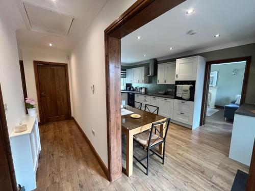 a kitchen with a wooden table and a dining room at Spacious modern three Bedroom Bungalow ample parking
