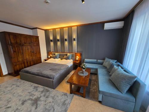 une chambre avec un lit, un canapé et une table dans l'établissement Family Luxury Private Apartments in 4 star SPA Resort St Ivan Rilski, Bansko, à Bansko