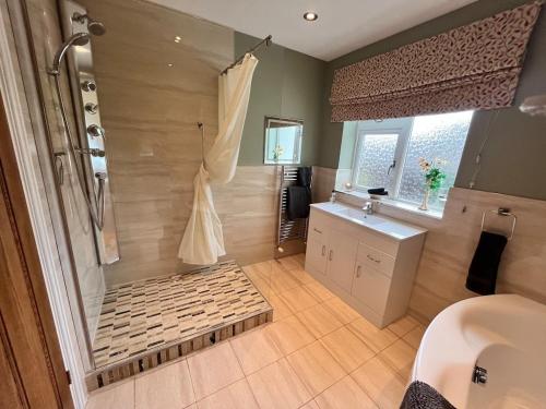 a bathroom with a shower and a sink at Spacious modern three Bedroom Bungalow ample parking