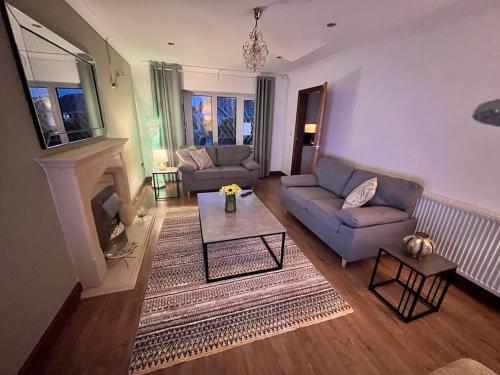 a living room with a couch and a fireplace at Spacious modern three Bedroom Bungalow ample parking