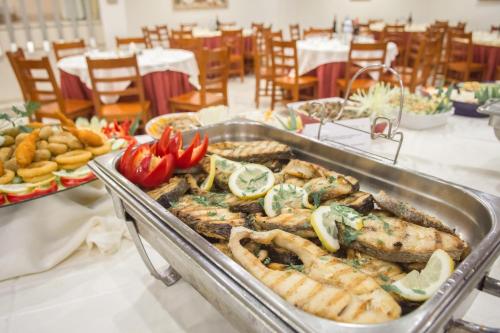 a buffet of food with fish and vegetables on a table at Hotel Cristal Caldas in Caldas da Rainha