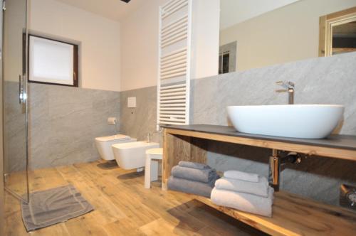 a bathroom with a sink and two toilets at Borch Chalet - Exclusive Apartments in Livigno