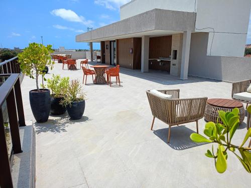 a patio with chairs and tables on a building at Aquach Beach Residence in Tamandaré