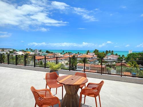a patio with a table and chairs and the ocean at Aquach Beach Residence in Tamandaré