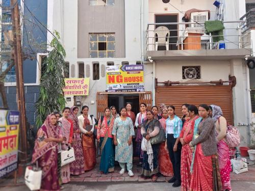 un grupo de mujeres frente a un edificio en Narmada Gest House, en Indore