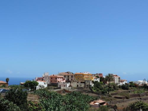 a group of houses on a hill with the ocean in the background at Casa Rural Los Helechos in Agulo