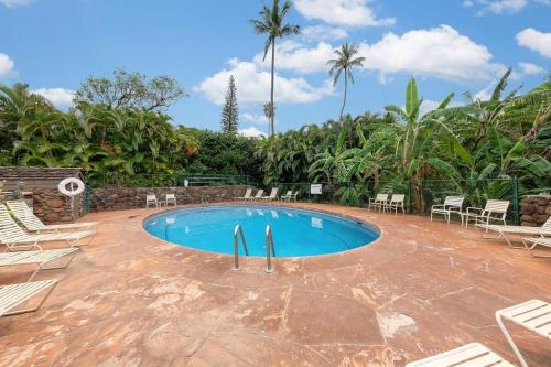 a swimming pool in a resort with chairs and trees at Kaanapali Plantation 11 · Modern Luxury Near Beach in Lahaina