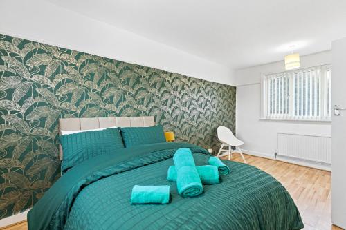 a bedroom with a green bed with blue pillows at Comfy 3Bedroom Manchester Getaway in Manchester