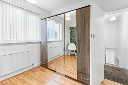 a hallway with a glass door and a chair at Comfy 3Bedroom Manchester Getaway in Manchester