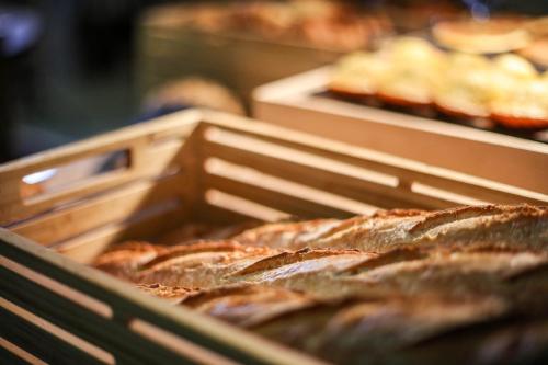 a bunch of loaves of bread in wooden trays at ibis Orange Centre in Orange