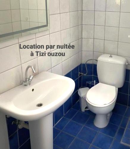 une salle de bain avec un lavabo blanc et des toilettes dans l'établissement Location appartement familial, à Tizi Ouzou