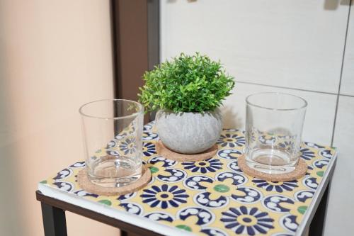 een tafel met twee glazen en een potplant erop bij Shipu Hotel in Pu-pien