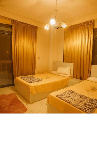 a hotel room with two beds and a window at Cairo Airport Oasis Cozy Convenient in Obour