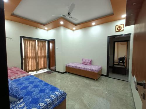 a bedroom with a bed and a chair and a window at Swami Bhakt Nivas in Tuljapur