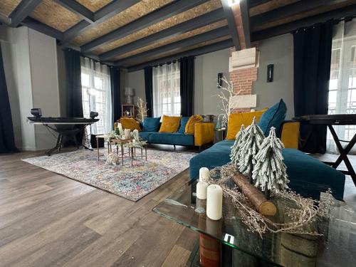 un salon avec un canapé bleu et une table dans l'établissement Le Manoir du Bonheur, à Chaumes-en-Brie