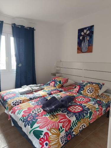 a bed with a colorful blanket and pillows on it at Alíseos in Costa de Antigua