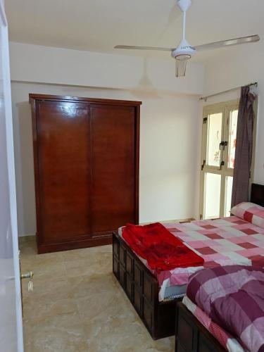 a bedroom with a bed and a wooden door at One room apartment in Marsa Alam City