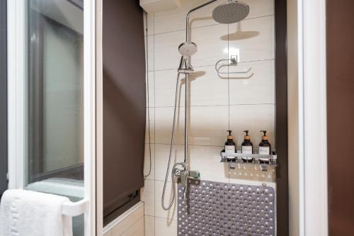 een badkamer met een douche en flessen aan de muur bij Shipu Hotel in Pu-pien