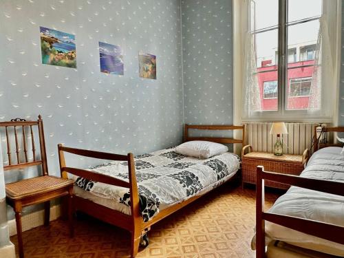 een slaapkamer met twee bedden en een raam bij Chez Francine et Auguste in Le Puy en Velay