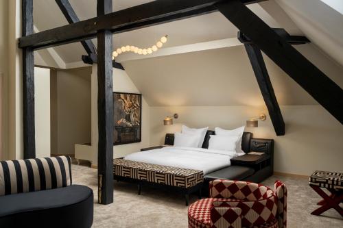 ein Hotelzimmer mit einem Bett und einem Stuhl in der Unterkunft Domeniile Martinutzi - Hotel Cardinal si Conac Rhedey in Alba Iulia