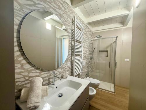 een badkamer met een wastafel en een spiegel en een toilet bij Silvium 23 - Affitti Brevi Italia in Gravina in Puglia