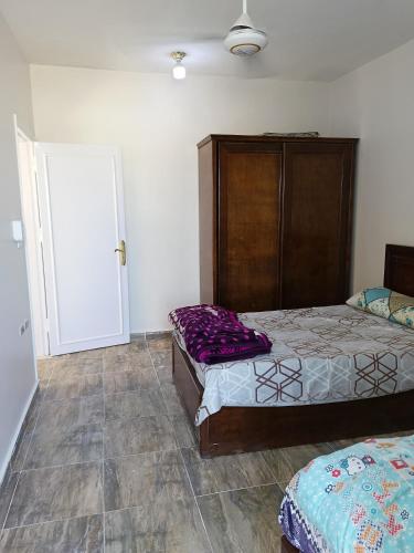 a bedroom with two beds and a closet and a door at Guest House Science 1 in Marsa Alam City