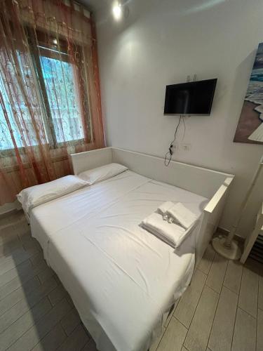 a white bed in a room with a tv on the wall at Suite Mondial - Rapallo Centro Mare & Wifi in Rapallo