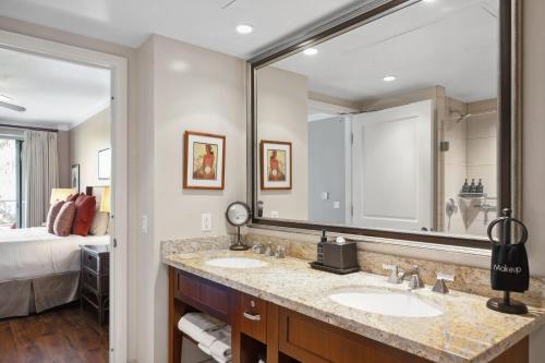 a bathroom with two sinks and a large mirror at Honua Kai Konea 204 in Lahaina