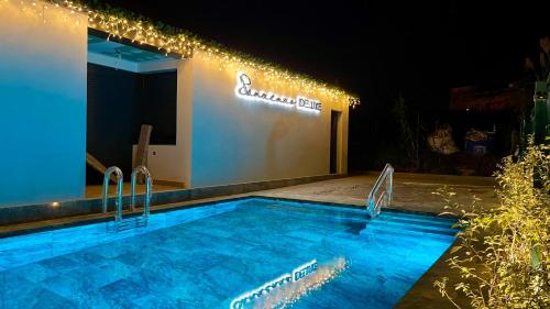 - une piscine en face d'un bâtiment éclairé dans l'établissement Sanxenxo Deluxe Apartamentos, à Sanxenxo