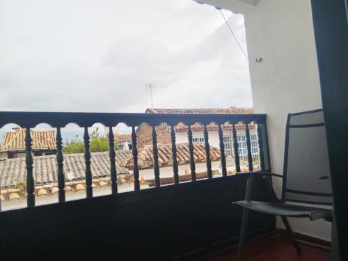 einen Balkon mit einem Zaun und einem Stuhl in der Unterkunft Casona Antonio Ricaurte in Villa de Leyva