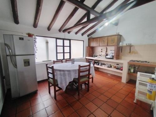 eine Küche mit einem Tisch mit Stühlen und einem Kühlschrank in der Unterkunft Casona Antonio Ricaurte in Villa de Leyva