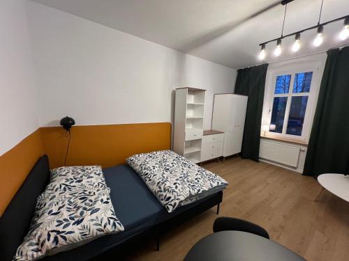 une petite chambre avec un lit et une fenêtre dans l'établissement Apartamenty Cytryn, à Gliwice