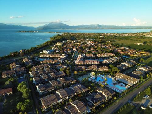 una vista aerea di un resort vicino all'acqua di Platino Apartment - Jacuzzi privata, tre Piscine residenziali ed un bar a 200m dal Lago a Desenzano del Garda