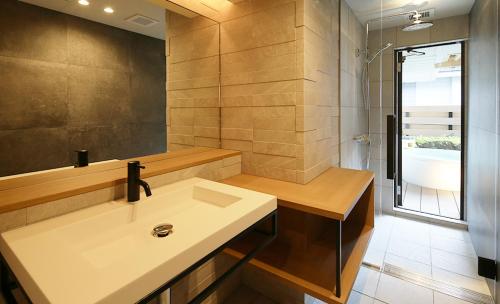 Un baño con lavabo y ducha en Shoenso Hozugawatei, en Kameoka