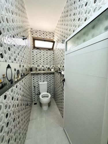 a bathroom with a toilet and a shower stall at Casa Wavy in Taghazout