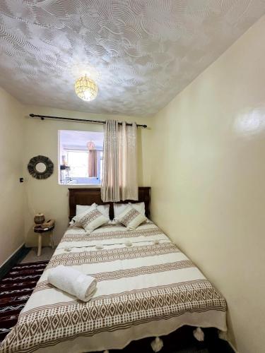 a bedroom with a bed and a window at Casa Wavy in Taghazout