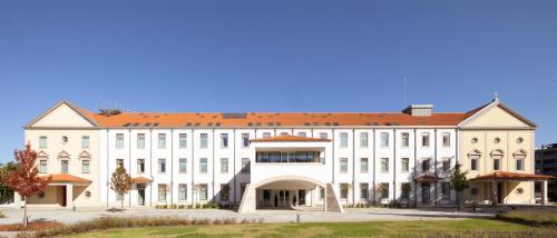 a large white building with a red roof at Stella Braga Aparthotel in Braga