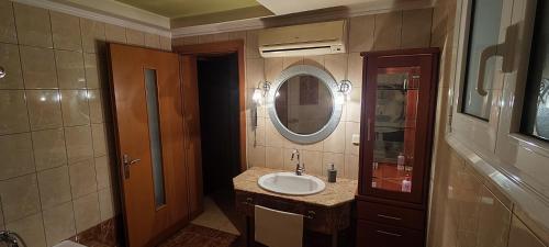 een badkamer met een wastafel en een spiegel bij Luxurious Apartment Drama in Drama