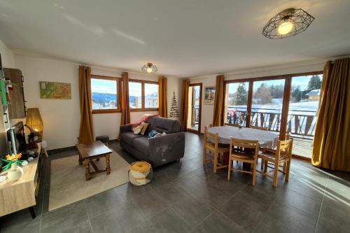 ein Wohnzimmer mit Sofa und Tisch in der Unterkunft Spacieux appartement au pied des pistes in La Feclaz