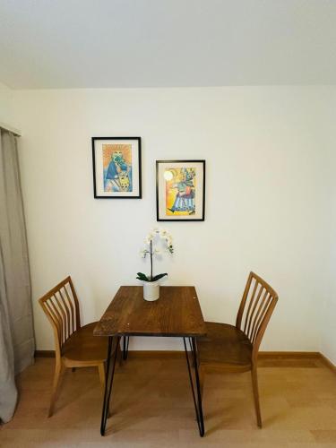 a table with two chairs and a vase with flowers on it at Hostel City Basel 366 in Basel
