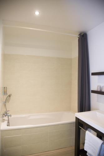 a bathroom with a tub and a sink at Auberge de la Baie in Ardevon