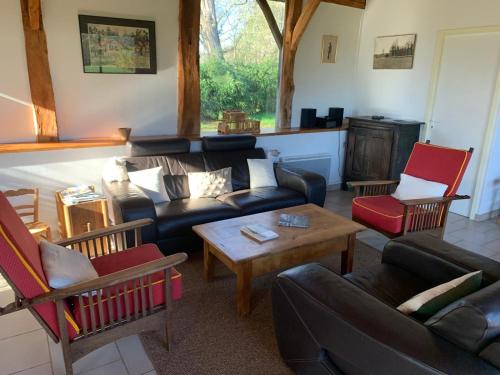un soggiorno con un divano, sedie e un tavolo di Bergerie bucolique a Balizac