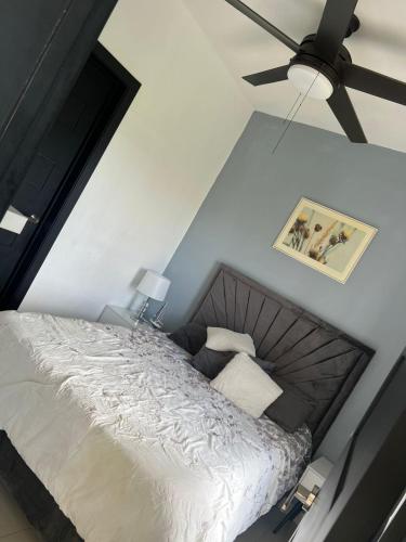 a bedroom with a bed and a ceiling fan at Perfecto para 3 personas. in Boca Chica